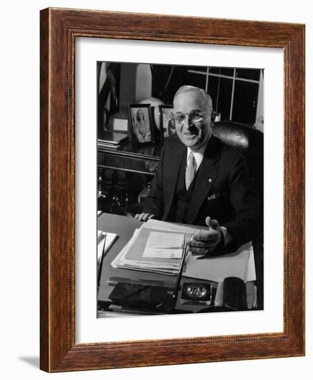 Pres. Harry S. Truman Seated at His Desk in the White House, Family Photographs on Table Behind Him-Gjon Mili-Framed Photographic Print