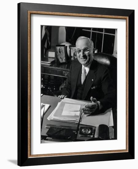 Pres. Harry S. Truman Seated at His Desk in the White House, Family Photographs on Table Behind Him-Gjon Mili-Framed Photographic Print