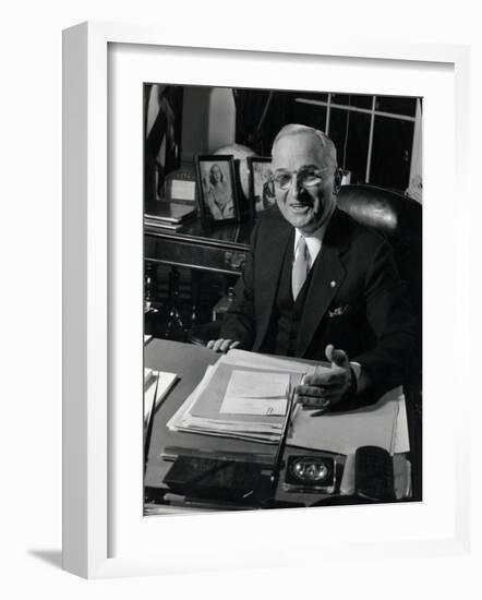 Pres. Harry S. Truman Seated at His Desk in the White House, Family Photographs on Table Behind Him-Gjon Mili-Framed Photographic Print