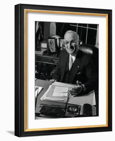 Pres. Harry S. Truman Seated at His Desk in the White House, Family Photographs on Table Behind Him-Gjon Mili-Framed Photographic Print