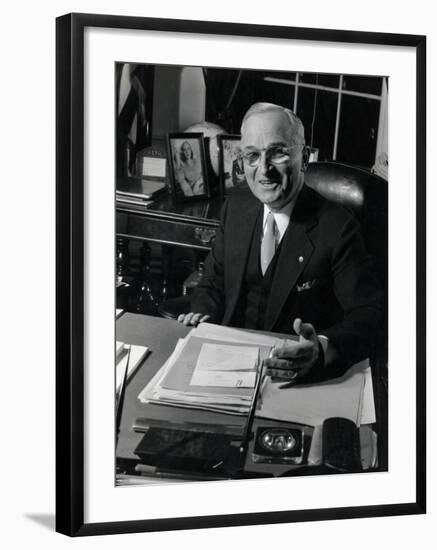 Pres. Harry S. Truman Seated at His Desk in the White House, Family Photographs on Table Behind Him-Gjon Mili-Framed Photographic Print