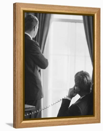 Pres. John F. Kennedy on Telephone While Brother, Attorney General Robert F. Kennedy Stands Nearby-Art Rickerby-Framed Premier Image Canvas