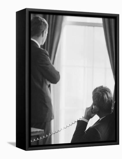 Pres. John F. Kennedy on Telephone While Brother, Attorney General Robert F. Kennedy Stands Nearby-Art Rickerby-Framed Premier Image Canvas