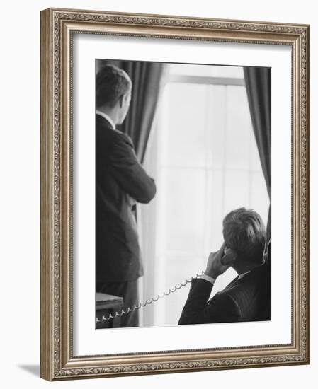 Pres. John F. Kennedy on Telephone While Brother, Attorney General Robert F. Kennedy Stands Nearby-Art Rickerby-Framed Photographic Print