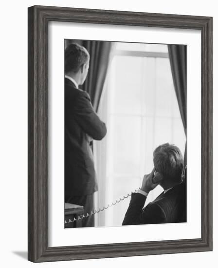 Pres. John F. Kennedy on Telephone While Brother, Attorney General Robert F. Kennedy Stands Nearby-Art Rickerby-Framed Photographic Print