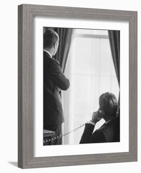 Pres. John F. Kennedy on Telephone While Brother, Attorney General Robert F. Kennedy Stands Nearby-Art Rickerby-Framed Photographic Print