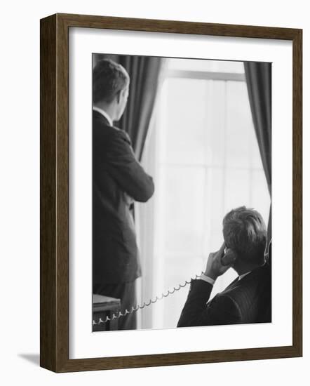 Pres. John F. Kennedy on Telephone While Brother, Attorney General Robert F. Kennedy Stands Nearby-Art Rickerby-Framed Photographic Print