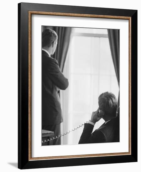 Pres. John F. Kennedy on Telephone While Brother, Attorney General Robert F. Kennedy Stands Nearby-Art Rickerby-Framed Photographic Print