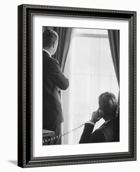 Pres. John F. Kennedy on Telephone While Brother, Attorney General Robert F. Kennedy Stands Nearby-Art Rickerby-Framed Photographic Print