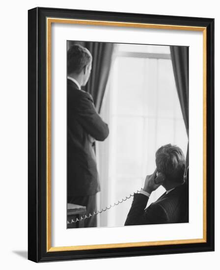 Pres. John F. Kennedy on Telephone While Brother, Attorney General Robert F. Kennedy Stands Nearby-Art Rickerby-Framed Photographic Print