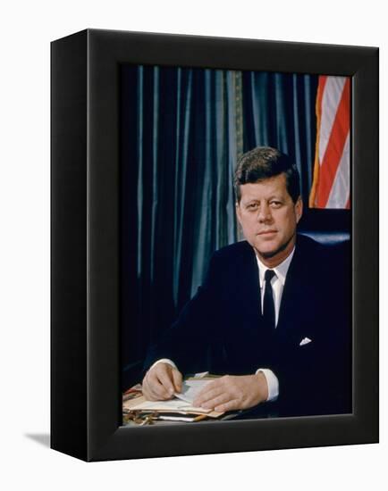 Pres. John F. Kennedy Sitting at His Desk, with Flag in Bkgrd-Alfred Eisenstaedt-Framed Premier Image Canvas