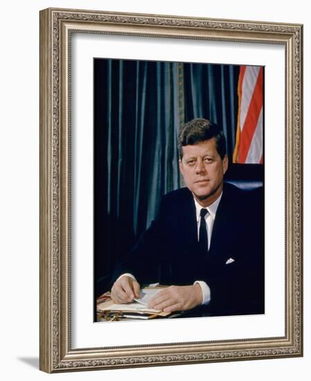 Pres. John F. Kennedy Sitting at His Desk, with Flag in Bkgrd-Alfred Eisenstaedt-Framed Photographic Print