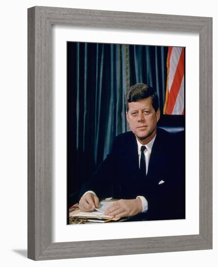 Pres. John F. Kennedy Sitting at His Desk, with Flag in Bkgrd-Alfred Eisenstaedt-Framed Photographic Print