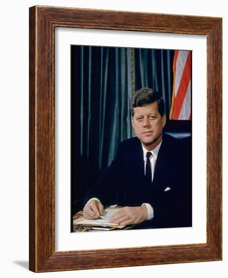 Pres. John F. Kennedy Sitting at His Desk, with Flag in Bkgrd-Alfred Eisenstaedt-Framed Photographic Print