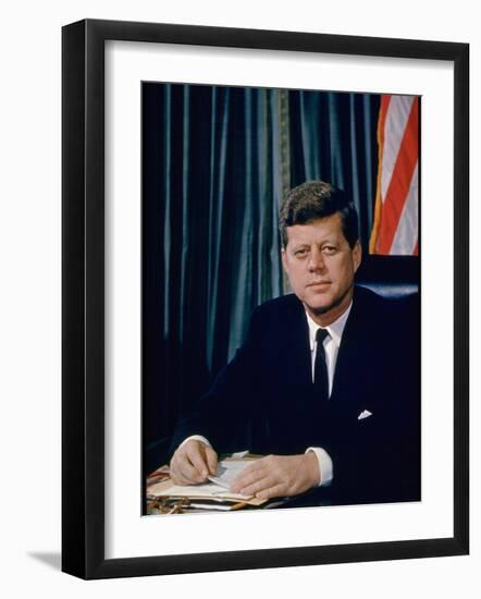 Pres. John F. Kennedy Sitting at His Desk, with Flag in Bkgrd-Alfred Eisenstaedt-Framed Photographic Print