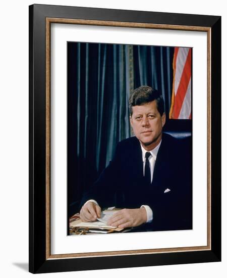 Pres. John F. Kennedy Sitting at His Desk, with Flag in Bkgrd-Alfred Eisenstaedt-Framed Photographic Print