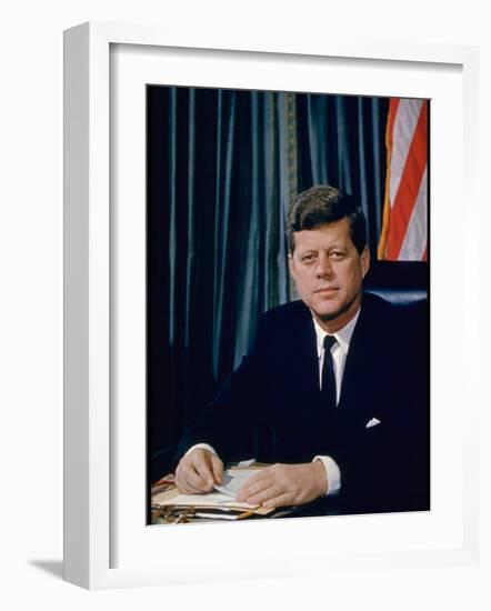 Pres. John F. Kennedy Sitting at His Desk, with Flag in Bkgrd-Alfred Eisenstaedt-Framed Photographic Print