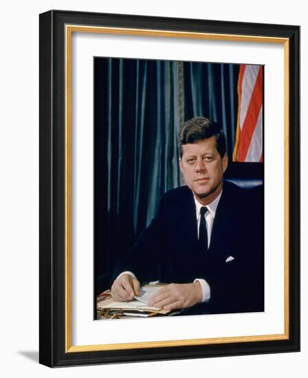 Pres. John F. Kennedy Sitting at His Desk, with Flag in Bkgrd-Alfred Eisenstaedt-Framed Photographic Print