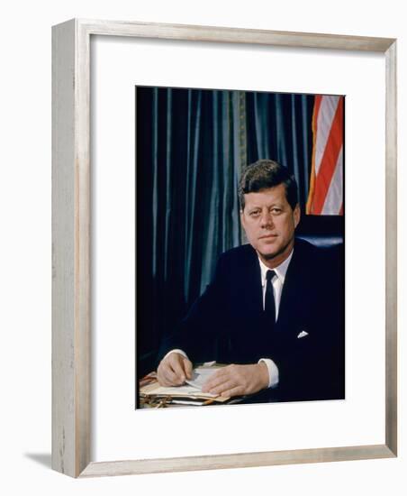 Pres. John F. Kennedy Sitting at His Desk, with Flag in Bkgrd-Alfred Eisenstaedt-Framed Photographic Print