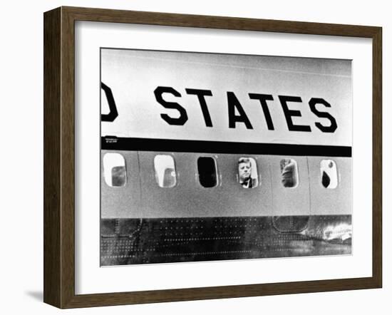 President John Kennedy Peers Out from Window of Air Force One-null-Framed Photo