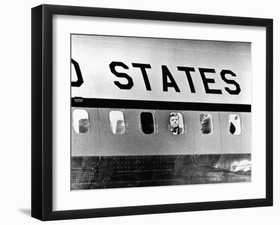 President John Kennedy Peers Out from Window of Air Force One-null-Framed Photo