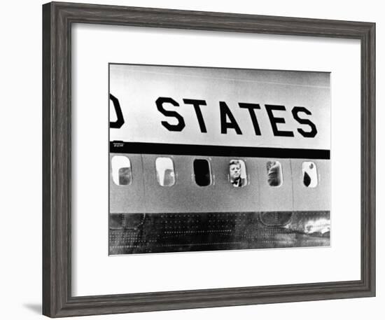 President John Kennedy Peers Out from Window of Air Force One-null-Framed Photo