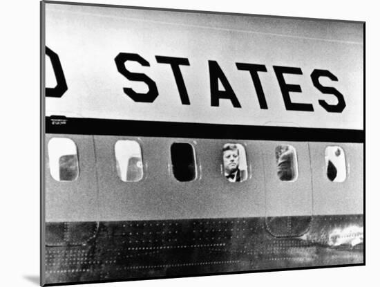 President John Kennedy Peers Out from Window of Air Force One-null-Mounted Photo