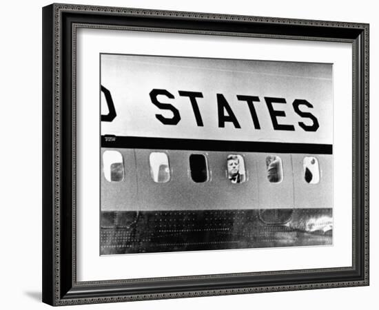 President John Kennedy Peers Out from Window of Air Force One-null-Framed Photo