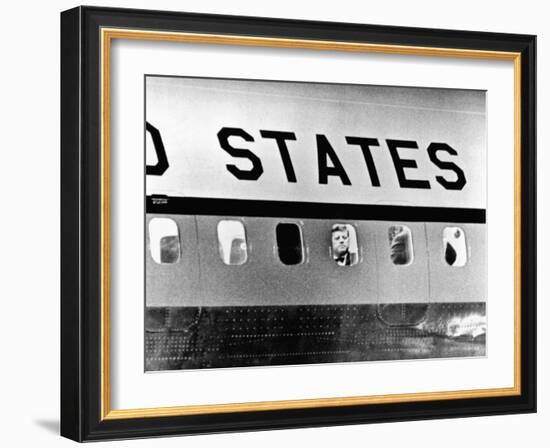 President John Kennedy Peers Out from Window of Air Force One-null-Framed Photo