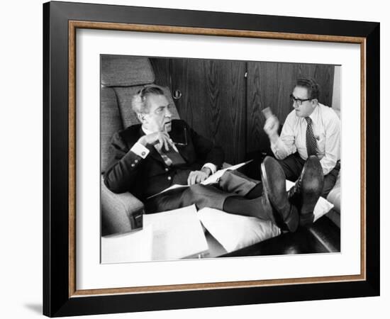 President Richard Nixon and Henry Kissinger Talking on Air Force One-null-Framed Photo