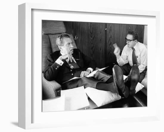 President Richard Nixon and Henry Kissinger Talking on Air Force One-null-Framed Photo