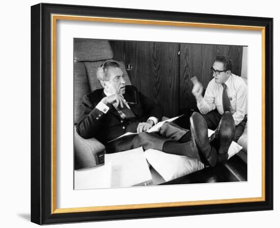 President Richard Nixon and Henry Kissinger Talking on Air Force One-null-Framed Photo