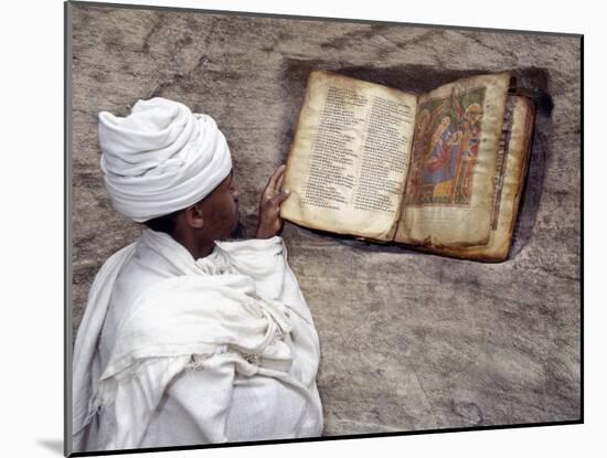 Priest of Ethiopian Orthodox Church Reads Old Bible at Rock-Hewn Church of Yohannes Maequddi-Nigel Pavitt-Mounted Photographic Print