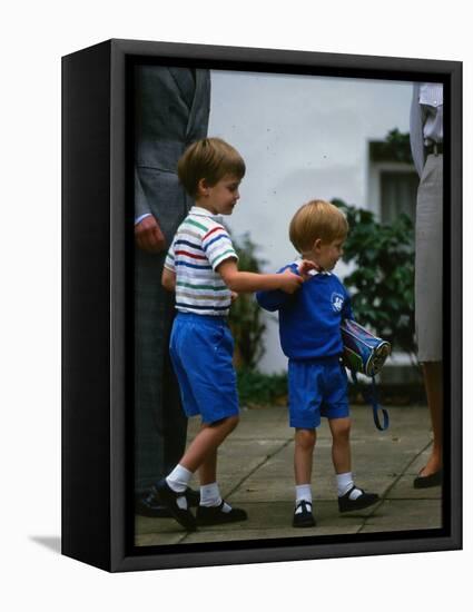 Prince Harry wearing a blue sweatshirt shorts and thomas the tank engine bag with Prince William on-null-Framed Premier Image Canvas