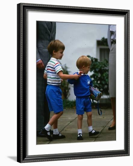 Prince Harry wearing a blue sweatshirt shorts and thomas the tank engine bag with Prince William on-null-Framed Photographic Print