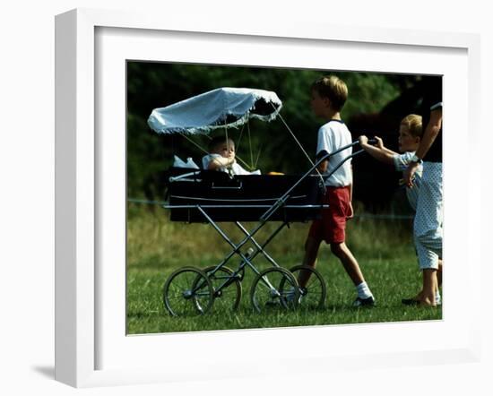 Princess Beatrice is being pushed in pram by Prince william and Harry-null-Framed Photographic Print