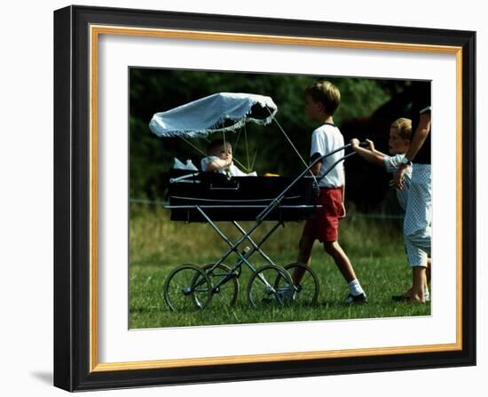 Princess Beatrice is being pushed in pram by Prince william and Harry-null-Framed Photographic Print