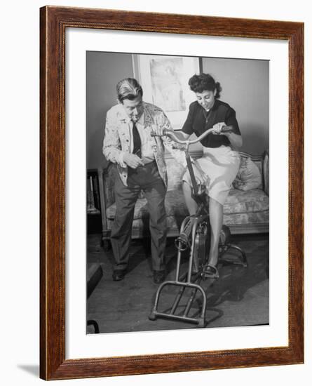 Producer-Director Preston Sturges and His Secretary Trying Out an Exercise Bicycle-John Florea-Framed Premium Photographic Print