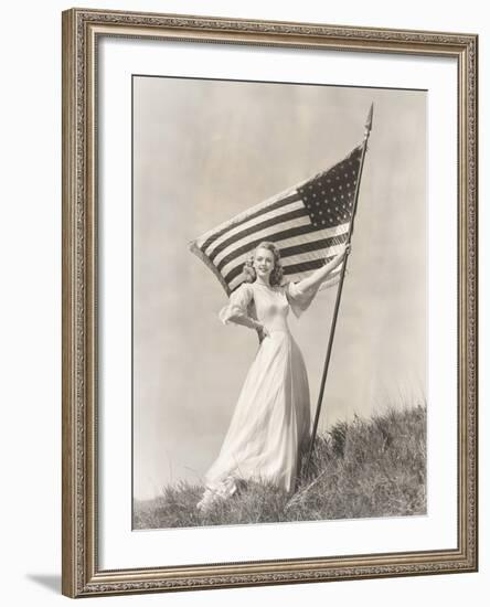 Proud Woman in Gown Holding American Flag on Hill-null-Framed Photo