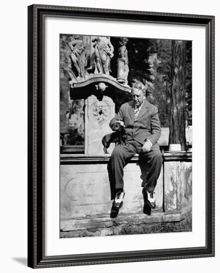 Publisher William Randolph Hearst Sr, Petting Dachshund Gandhi While Sitting on Edge of Fountain-Peter Stackpole-Framed Premium Photographic Print