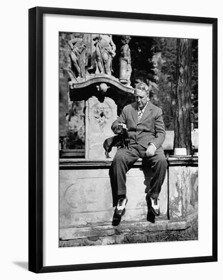 Publisher William Randolph Hearst Sr, Petting Dachshund Gandhi While Sitting on Edge of Fountain-Peter Stackpole-Framed Premium Photographic Print