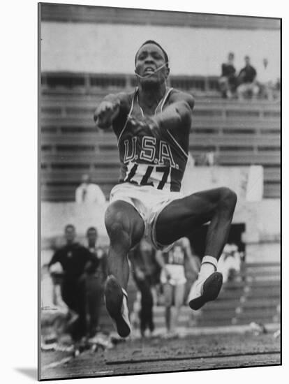 Rafer Johnson in Decathlon Broad Jump in Olympics-James Whitmore-Mounted Premium Photographic Print