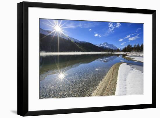 Rays of winter sun illuminate Lake Silvaplana still partially frozen Maloja Engadine Graubunden Can-ClickAlps-Framed Photographic Print