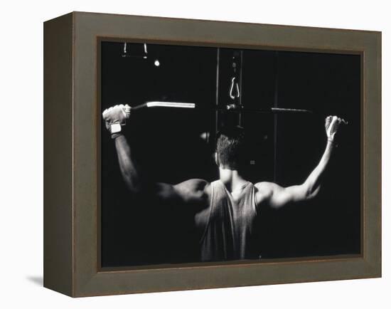 Rear View of a Young Man Exercise on a Lateral Pull-Down Weight Machine-null-Framed Premier Image Canvas