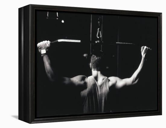 Rear View of a Young Man Exercise on a Lateral Pull-Down Weight Machine-null-Framed Premier Image Canvas