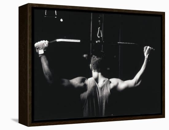 Rear View of a Young Man Exercise on a Lateral Pull-Down Weight Machine-null-Framed Premier Image Canvas