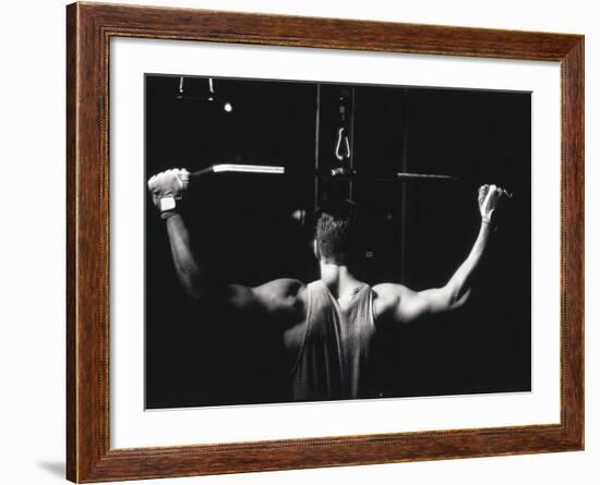 Rear View of a Young Man Exercise on a Lateral Pull-Down Weight Machine--Framed Photographic Print