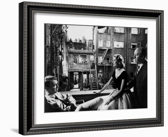 REAR WINDOW, 1954 directed byALFRED HITCHCOCK On the set, Grace Kelly between James Stewart and Alf-null-Framed Photo