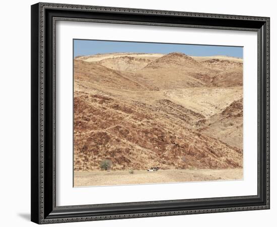 Red Rocky Landscape with Jeep in Distance, Purros Conservancy Wilderness, Kaokoland, Namibia-Kim Walker-Framed Photographic Print