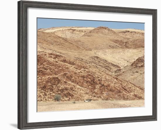 Red Rocky Landscape with Jeep in Distance, Purros Conservancy Wilderness, Kaokoland, Namibia-Kim Walker-Framed Photographic Print